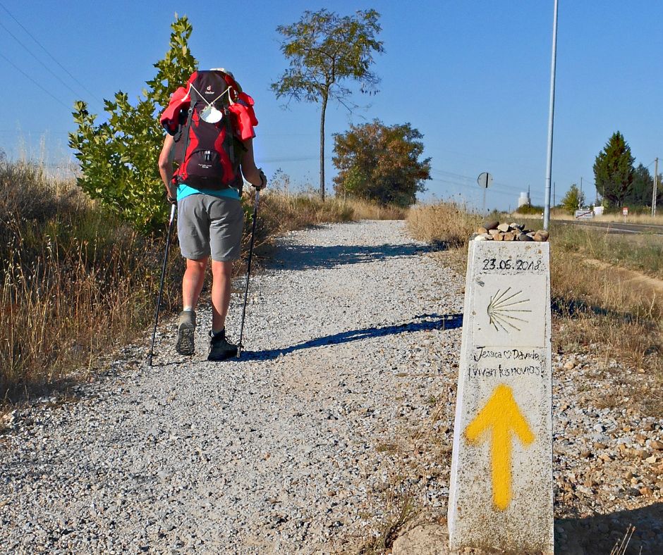 Pilger mit Rucksack läuft auf einem Weg.