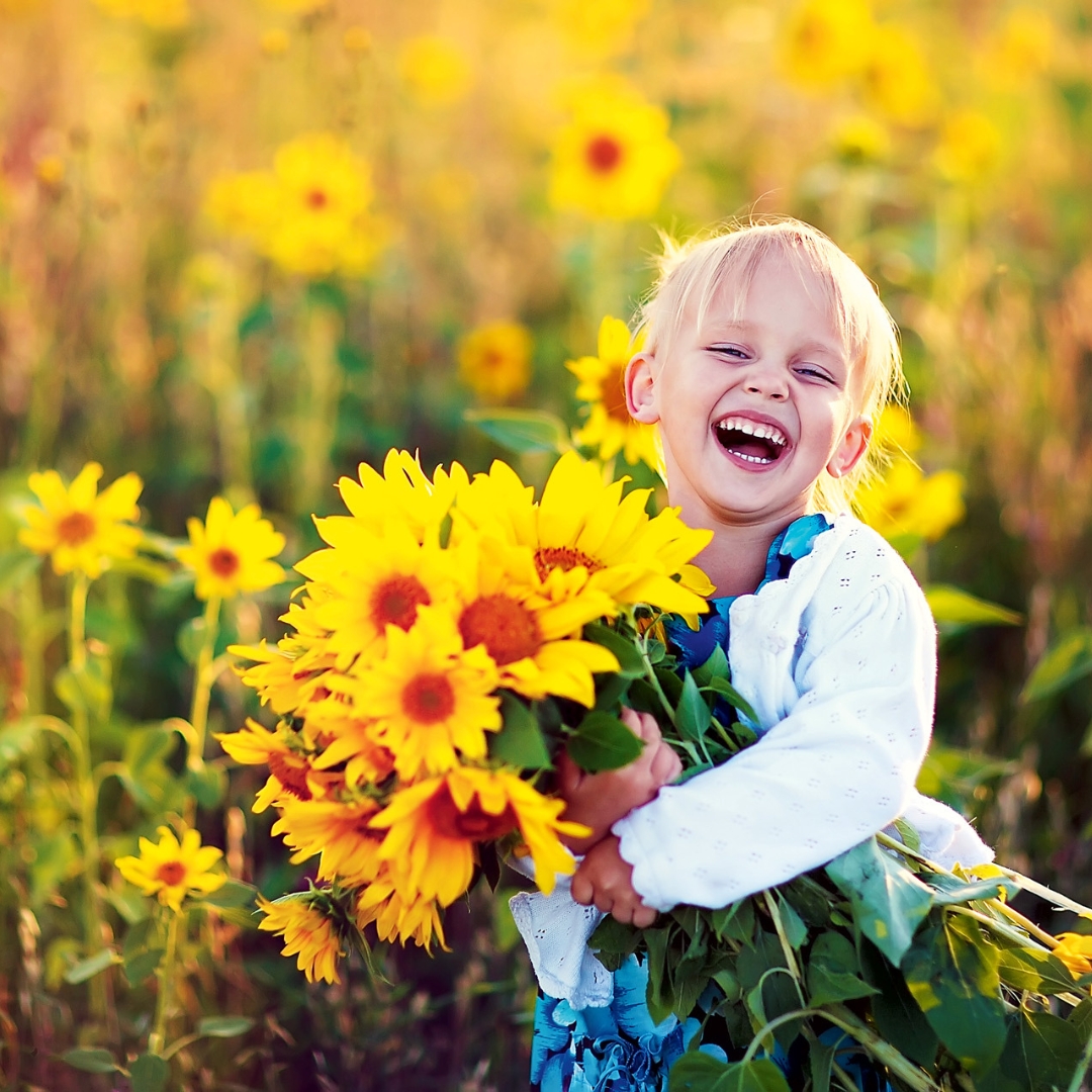 Ein Mädchen mit einem Strauß Sonnenblumen in einem Sonnenblumenfeld.