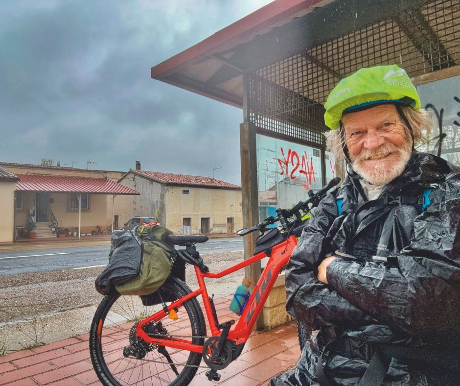 Werner Kräutler macht Pause mit seinem E-Bike vor einer Bushaltestelle